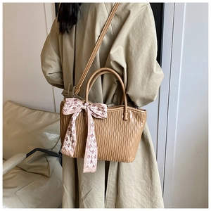 Detail of khaki pleated tote bag with pink plaid scarf and adjustable shoulder strap