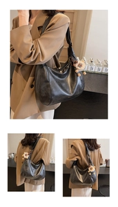 Dettaglio della borsa hobo in ecopelle nera con texture pieghettata e ciondolo peluche