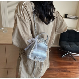 Vue détaillée d'un mini sac à dos argenté matelassé avec dentelle et perles élégantes