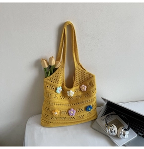 Close-up of yellow knit tote bag featuring colorful 3D crochet flowers and large capacity