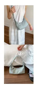 Dettaglio borsa hobo azzurra a grana lychee con cerniera argento e ciondolo unico