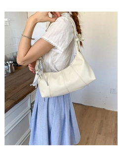 Dettaglio della borsa hobo crema con nodo in metallo e texture in pelle a grana
