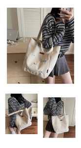 Detail of beige canvas tote bag with cute puppy embroidery and spacious interior structure