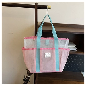 Detail of pink and blue mesh swimming bag with zipper and decorative text label