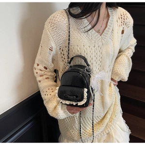 Détail du micro sac à dos en cuir verni noir avec dentelle et bandoulière chaîne