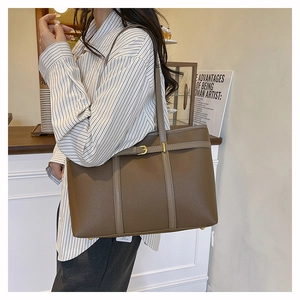 Close-up of brown litchi grain leather tote bag with gold hardware for office