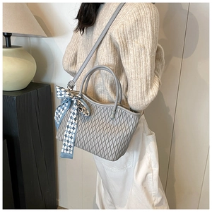 Detail of grey pleated tote bag featuring a checkered scarf and versatile shoulder strap