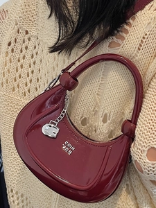 Dark red crescent handbag in glossy patent leather with silver hardware and ring handle