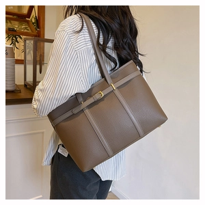 Close-up of deep brown tote bag featuring premium lychee texture leather and buckle