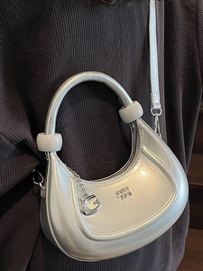 Silver crescent hobo bag with metallic finish, stylish round handle and slim strap