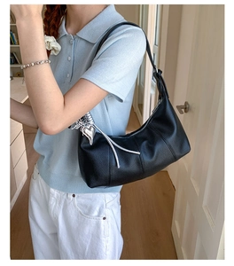 Dettaglio borsa hobo in pelle martellata nera con ciondolo a cuore e nappe in argento