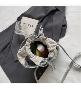 Intérieur spacieux du sac seau argenté montrant le rangement pour téléphone et maquillage