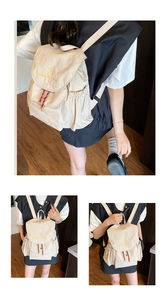 Vistas detalladas de una mochila de lona crema minimalista con bordado de texto