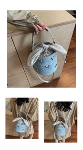 Détail du sac seau en denim avec breloques papillons et fermeture à nœud oreilles de lapin