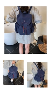 Detalle de mochila de lona azul marino con bordado rosa y cordón de ajuste tejido suave