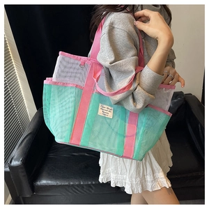 Detail of pink and green mesh tote bag with fashion label shown on a side-wear view