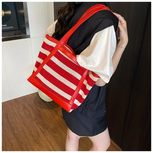 Red and white striped woven tote bag with leather straps shown on a model for daily use