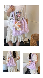 Detail view of purple gingham tote bag with cute plush puppy charm and pleated straps