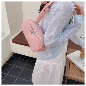 Rosa Umhängetasche aus Leder mit Lychee-Muster und Silberverschluss am Model getragen