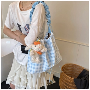 Blue and white checkered tote bag with ruffled shoulder strap and plush charm detail