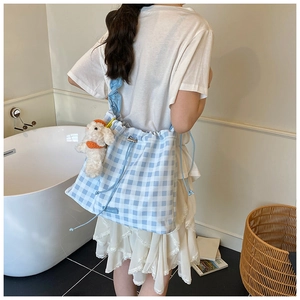 Blue gingham drawstring bag detail with ruffled shoulder strap and plush dog charm