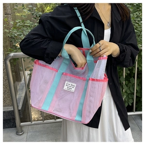 Close-up of pink and mint green mesh beach bag with side pocket and textile label
