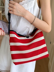 Knitted red and white striped tote bag with black leather straps and toggle closure
