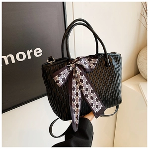 Detail of black tote bag with vertical ripple texture and a checkered bow scarf