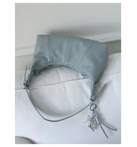Dettaglio della borsa hobo in pelle blu-grigio con ciondolo a cuore e farfalla