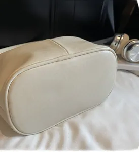 Détail du fond de sac à main beige en cuir grainé avec des coutures de haute qualité