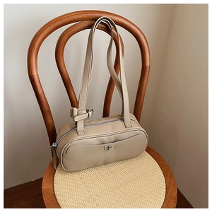 Detailaufnahme der erdfarbenen Handtasche aus Leder mit Narbenstruktur und Silberbeschlägen