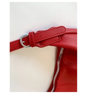 Dettaglio borsa rossa in pelle litchi con tracolla regolabile e fibbia in metallo argento
