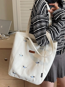 Minimalist canvas tote bag with embroidered dachshund and leather logo on shoulder