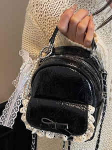Mini sac à dos noir effet froissé avec bordure en dentelle blanche et charme en perles