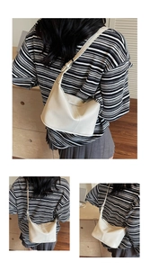 Détail du sac à bandoulière en cuir crème avec sangle réglable sur une tenue