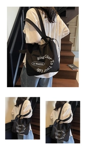 Detail view of black drawstring tote bag with Bring Color To Your Life text print