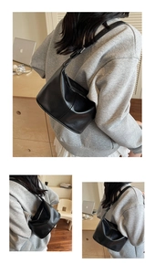 Détail d'un sac hobo noir montrant la bandoulière réglable et la boucle en métal argenté