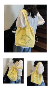 Detail of yellow nylon drawstring tote bag with green letter print and light texture