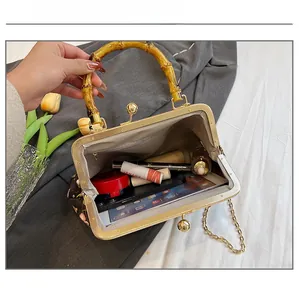 Detail of bamboo handle shell bag interior showing capacity for phone and cosmetics