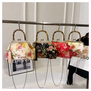 Detail of silk vintage bags with bamboo handles, tassels, and metal chains in four colors