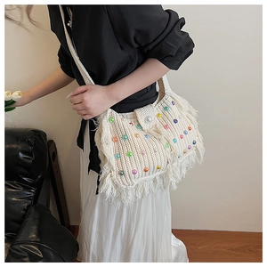 Détail d'un sac au crochet fait main avec perles colorées et longues franges