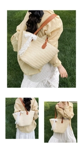 Detail of beige straw tote bag with brown PU handles and white lace bow on grass