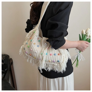 Vue détaillée du sac à bandoulière en tricot crème avec perles colorées et franges