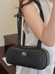 Minimalistische schwarze Schultertasche aus Leder mit silbernem Verschluss am Modell