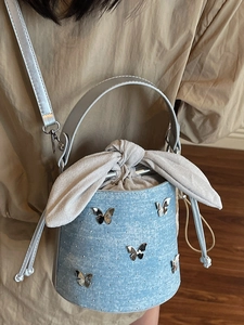Sac seau en jean bleu clair avec papillon en métal et bandoulière réglable