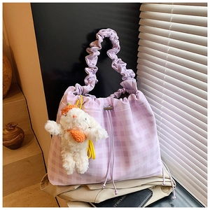 Detail of light purple checkered tote bag with drawstring closure and cute rabbit charm