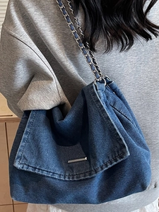 Blue denim tote bag with metal chain strap and minimalist silver bar buckle detail