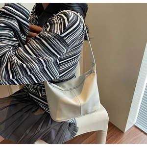 Détails du sac hobo beige minimaliste montrant la texture et la bandoulière souple