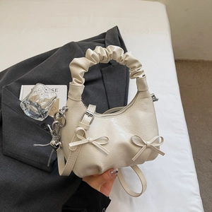 Detailed cream pleated cloud bag with bow ornament and silver heart charm