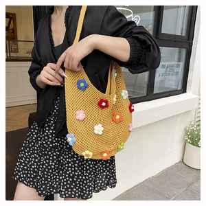 Close-up of yellow crochet tote bag with colorful 3D knitted flowers and mesh hollow design